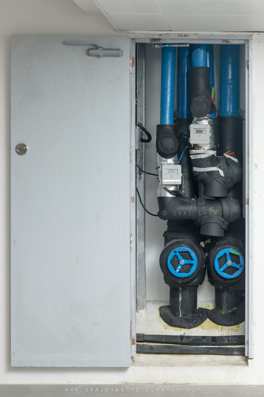 Open Tengah centralised cooling system riser showing insulated pipes, valves and utility equipment
