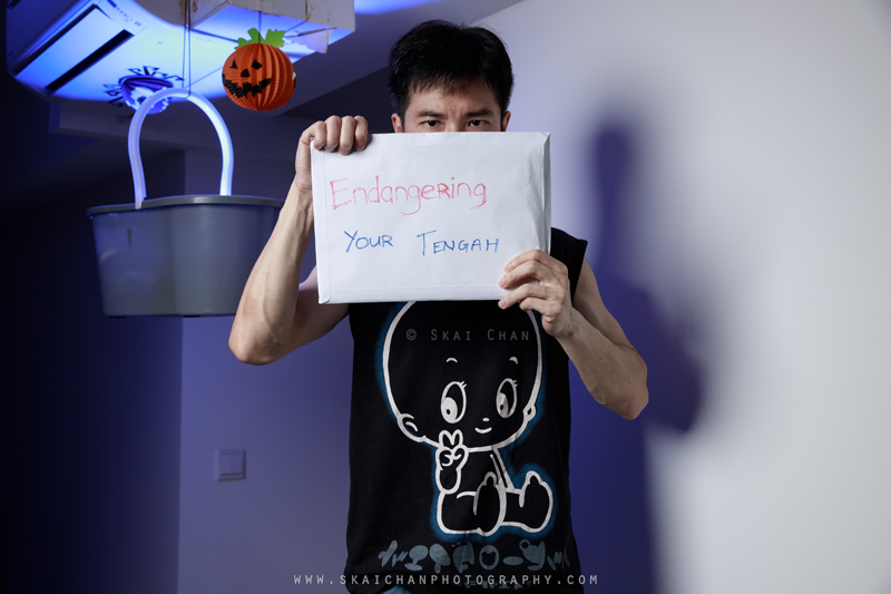 Skai wearing a ghost T-shirt and holding the handwritten EndangeRing YouR TENGAH sign in his Halloween self-portrait finale